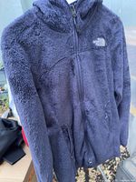 Front view of navy fleece jacket hanging
