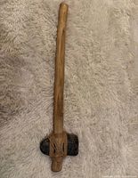 Full view of entire stone axe on fabric background