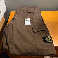Full view of folded cargo jogger pants showing color, fabric, overall condition