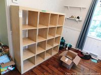 Full view of the wood storage cabinet showing the 16 square open compartments in a 4x4 grid layout.