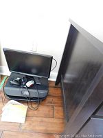 Full view of the computer monitor, HP Envy 4520 printer, two mice, and software case on a wooden floor.