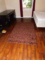 Full view of the 6x4 area carpet on hardwood floor between desk and bed.