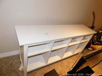 Full view of the white shelving unit showing its length and open compartments.