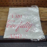 Folded blanket in plastic with visible quote text