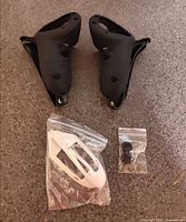 pair black silicone VR controller covers, white shell in bag, small bag of caps on carpet