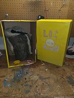 Log figure inside open yellow box with accessories visible