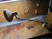 Full view of Vemcolite VL-4 lamp clamped to bench showing arm and shade