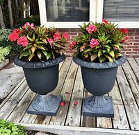 Both resin urn planters on deck with flowers visible