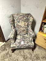Front view of wingback armchair showing upholstery pattern and missing seat cushion