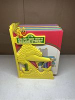 Front view of Sesame Street book set inside Big Bird plastic case showing colourful book spines