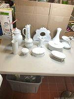 All twelve white porcelain items arranged on table
