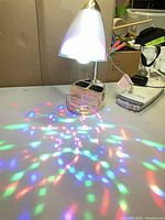 Lamp illuminated showing shade, stem, base and multicolor light pattern