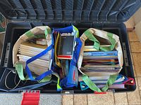 Three fabric tote bags filled with notebooks, folders, loose paper inside a storage bin