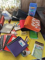 Overall view of notebooks, binders, drawer organizer, mouse, adhesive items on table