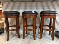 Front view of three matching wood bar stools