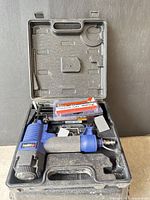 Open case showing nailer, nail box and loose nail strips