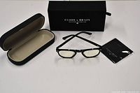 Full set showing sunglasses, hard case, presentation box and cloth