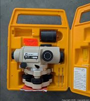 Automatic level seated in yellow case with accessories visible