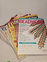 Stack of approximately 9 Beadwork and Bead & Button magazines, top copy dated Aug/Sept 2014