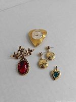 Front view of brooch, earrings, pendant, watch head