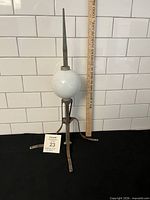 Full view of lightning rod with glass ball and ruler for scale