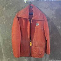 Full view of jacket front on hanger showing color, pockets and zipper