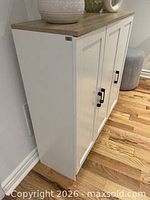 Cabinet angled view showing white body, oak top, three doors