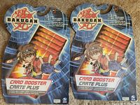 Front view of both sealed Bakugan Card Booster Crate Plus packs