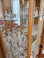 Cabinet shelves filled with upside-down lead crystal stemware and a footed serving bowl