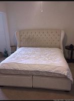 Full view of upholstered California king bedframe with mattress