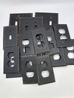 Front view pile of outlet and switch covers showing quantity and decorative border