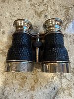 Front view of opera glasses showing leather grip and metal body