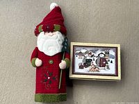 Plush Santa figure next to closed holiday stationery box