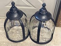 Two black metal lanterns side by side