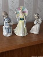 All three figurines side by side on shelf