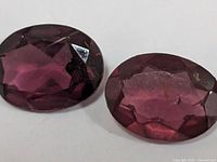 two oval faceted garnet gemstones close-up