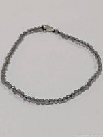 Full view of bracelet laid flat showing bead strand and clasp