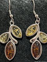 Front view of earrings displaying multicolour amber stones