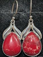 Front view of earrings showing red jasper stones and silver leaf mounts