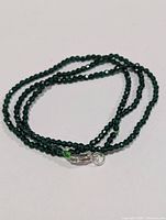 Coiled strand of faceted crystal beads showing clasp