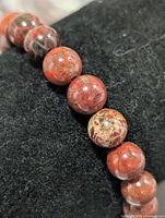 Close-up of individual red jasper beads on bracelet