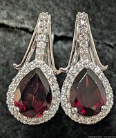 Front view showing garnet centers, CZ halo, silver mount