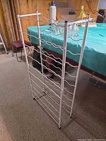 Full view of tall white metal wine rack standing on carpet