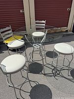 Entire set showing round glass table and four matching stools