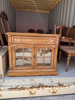 Front view showing drawer, glass doors, hardware, plinth base
