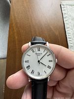 Front view showing dial, markers, hands, crown