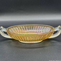 Front view showing amber carnival glass bowl with two clear handles