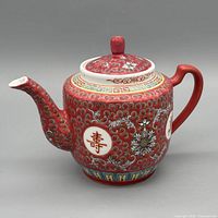 Left side view showing spout, handle, lid, decorative pattern