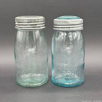 Front view of both aqua glass Crown jars with lids