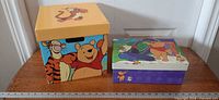 Cube and rectangular Winnie the Pooh themed boxes side by side